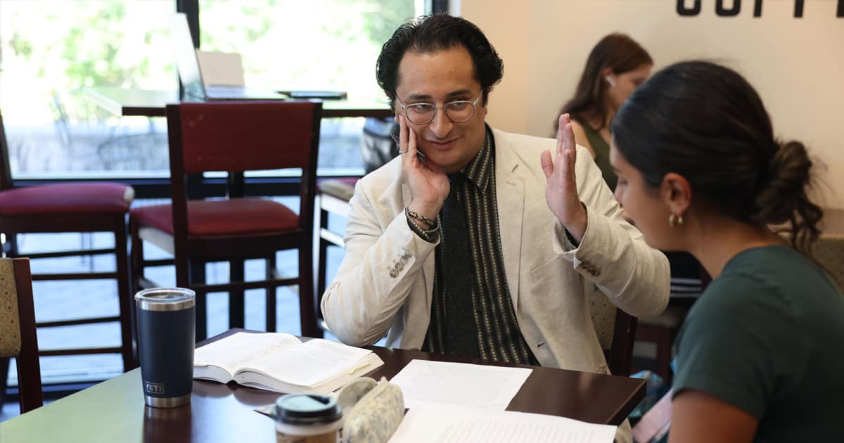 Dr. Alex Taylor helps a senior student with a paper.